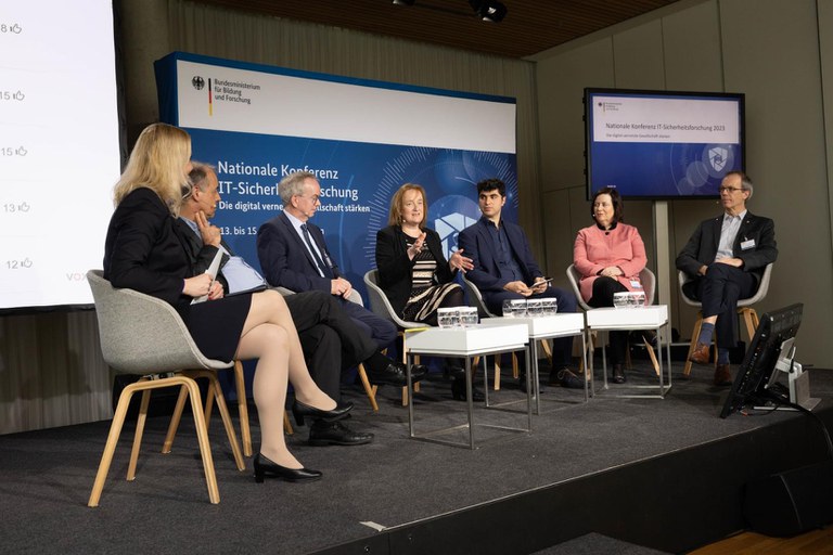 Carmen Hentschel (Moderatorin), Dr. Detlef Houdeau, Prof. Hans Schotten, Prof. Ina Schieferdecker, Prof. Esfandiar Mohammadi, Prof. Gabi Dreo Rodosek, Prof. Georg Sigl sitzen auf dem Podium