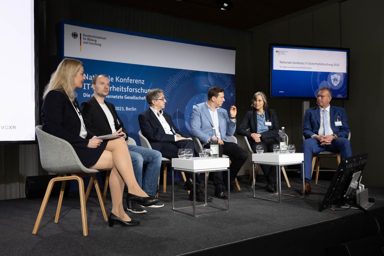 Sitzen auf dem Podium: Carmen Hentschel (Moderatorin), Dr.-Ing. Kai Jansen, Prof. Michael Waidner, Mario Brandenburg, Dr. h. c. Marit Hansen, Prof. Andreas Tünnermann. 