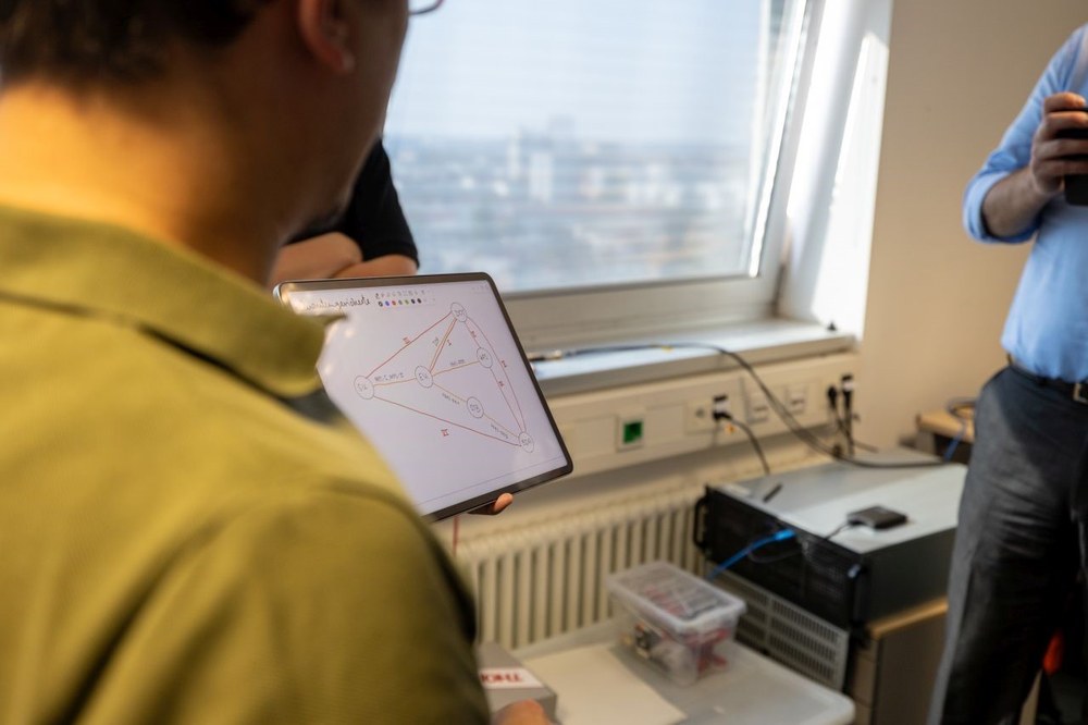 Forscher der QuNET-Initiative verdeutlichen anhand eines schematischen Schaubildes die Stern-Topologie des Netzwerks in Schlüsselexperiment 2.