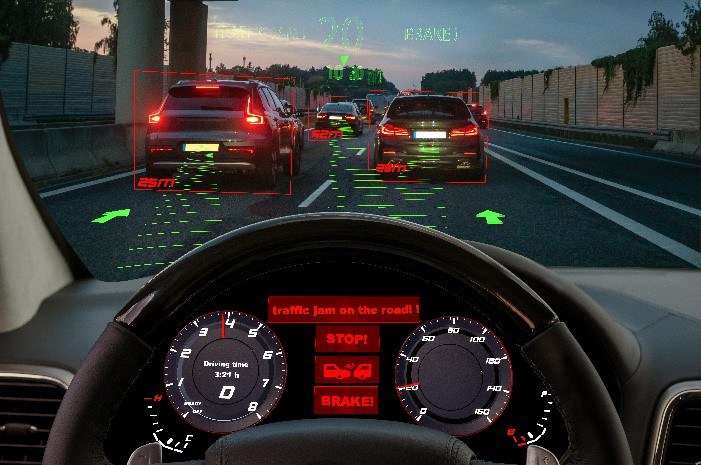 Blick auf das Cockpit eines mit  aktiven Sicherheitssystemen ausgestatteten Autos: Die Systeme haben einen Stau auf der Autobahn erkannt und eine Notbremsung eingeleitet