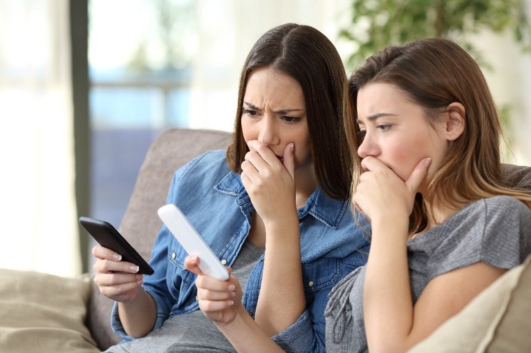 zwei Frauen schauen besorgt auf ihre Handys