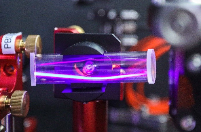 Bild einer Röhre mit lila Licht, das die Wechselwirkung eines Laserstrahls mit einer Rubidium-Atomdampfzelle zeigt. 