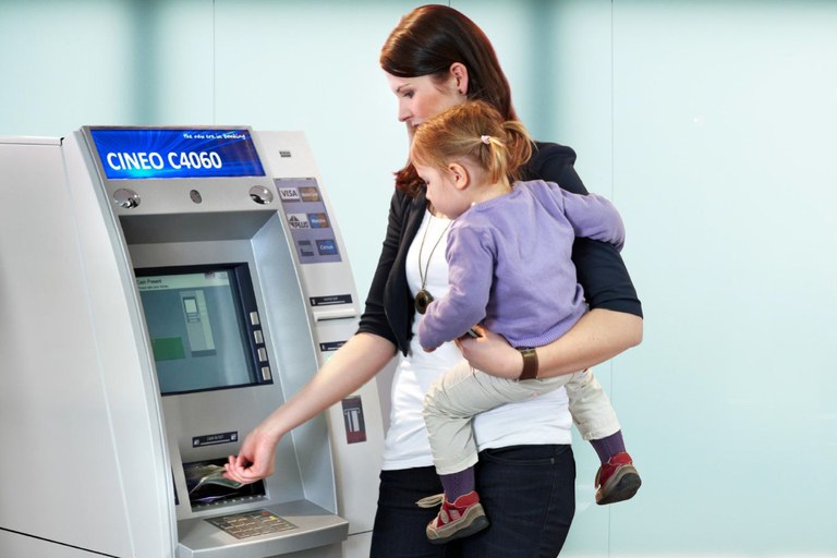 Frau mit Kind am Bankautomaten