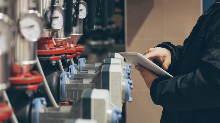 Ingenieur mit Tablet vor Wasserpumpen