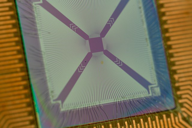Quantenphotonischer Chip mit vielen supraleitenden Einzelphotonendetektoren, die über Drahtbonds mit einer elektrischen Leiterplatte verbunden sind. 